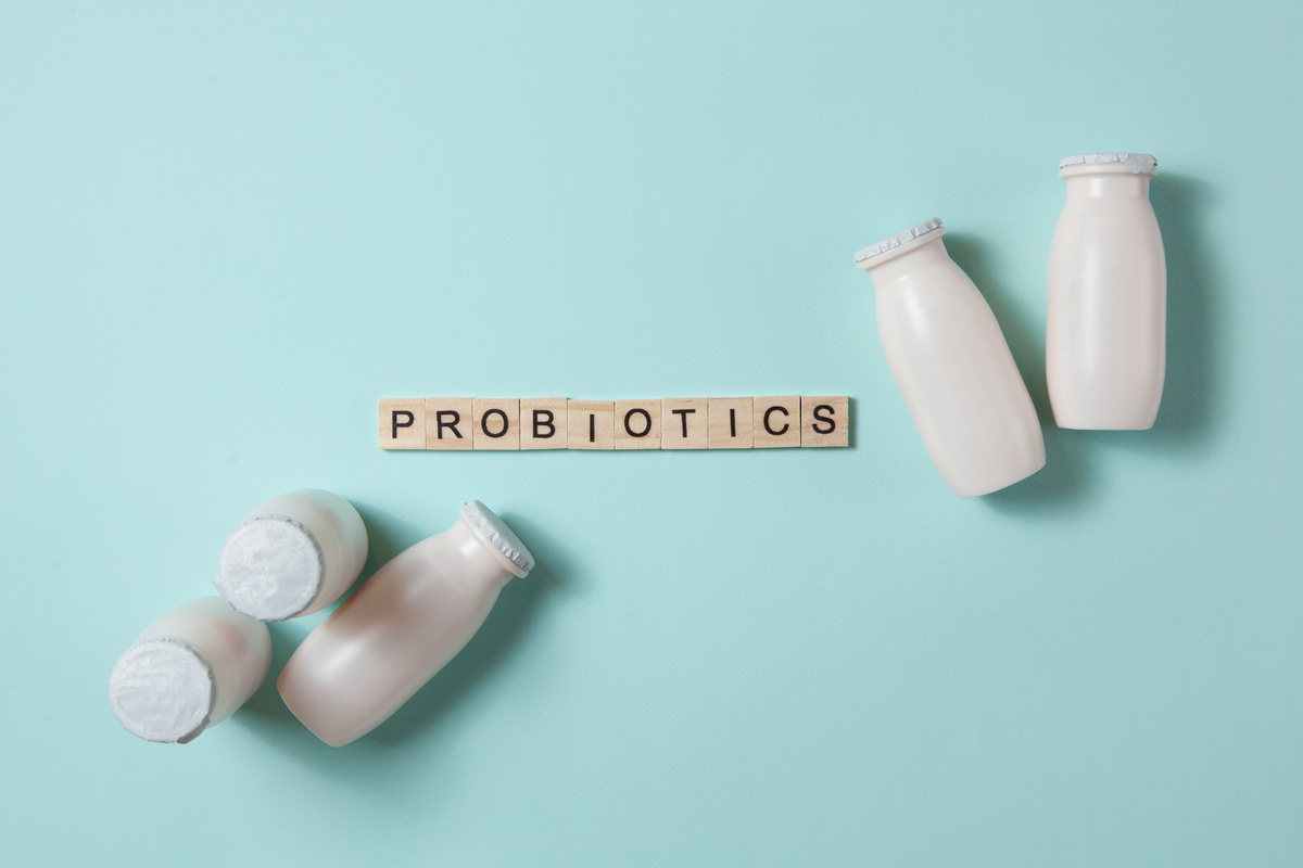 Placa de madeira escrito probioticos com garrafas de leite ao redor