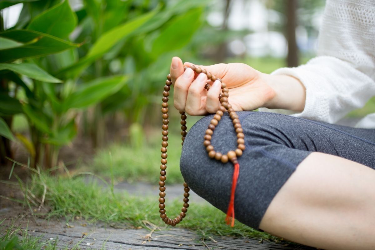 Mulher meditando segurando um japamala