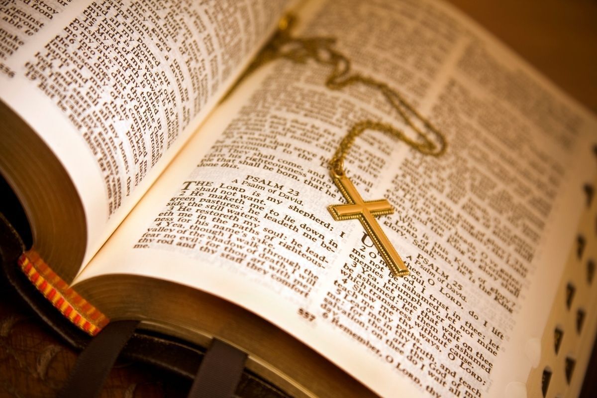 Bíblia Sagrada aberta nos Salmos e rosário em cima dela