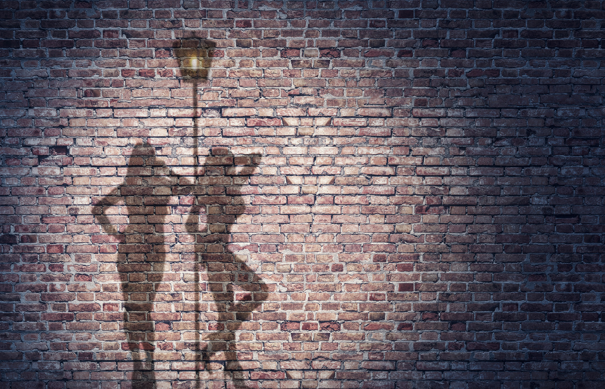 Parede de tijolos mostrando a sombra de duas mulheres prostitutas