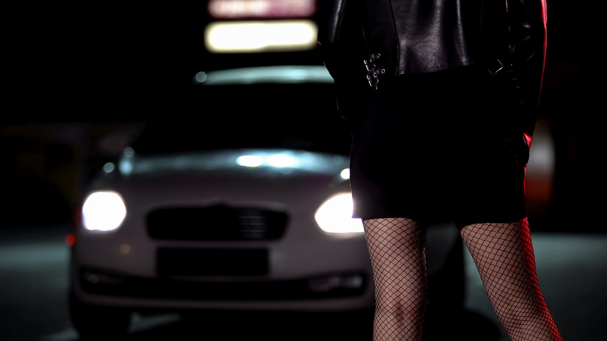 Prostituta numa rua noturna esperando seu cliente