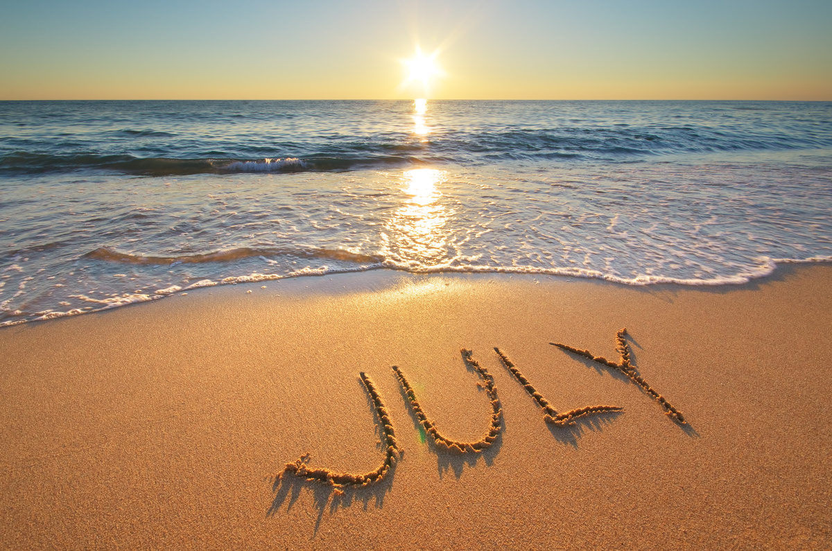 Palavra "julho" escrito na areia de uma praia