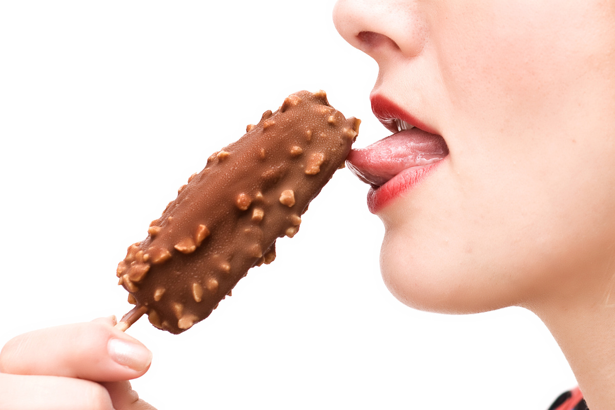 Mulher chupando picolé de chocolate