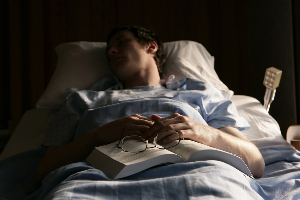 Homem dormindo com Bíblia e óculos no colo