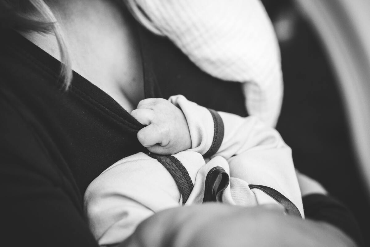 Imagem em preto e branco de mãe com bebê