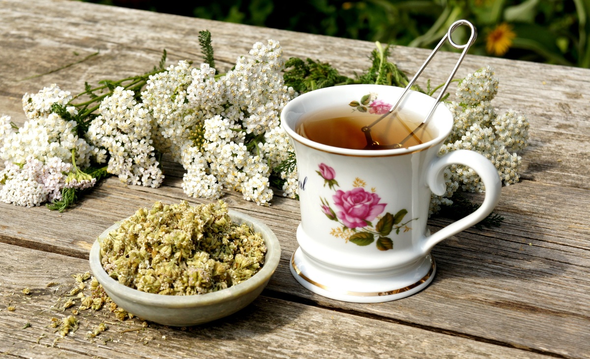 Chá de valeriana com as ervas ao lado.