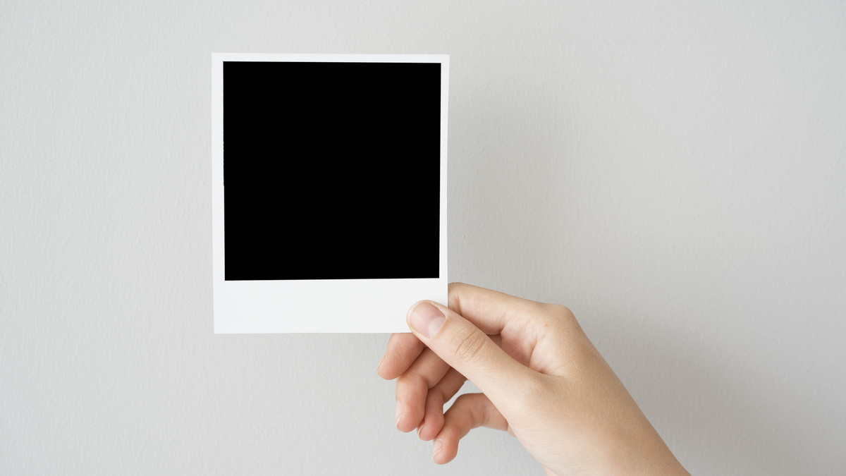 Pessoa segurando foto polaroid toda em preto