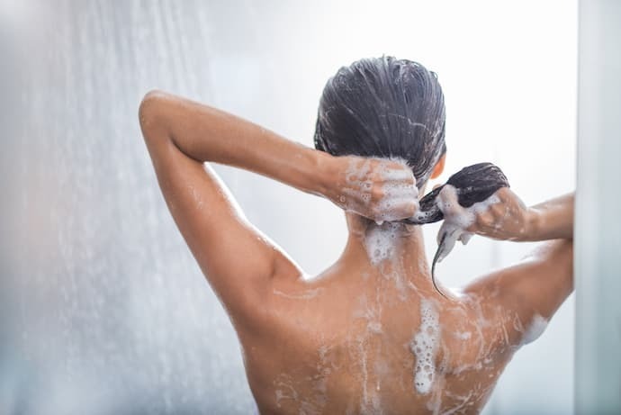 Mulher lavando cabelo no banho