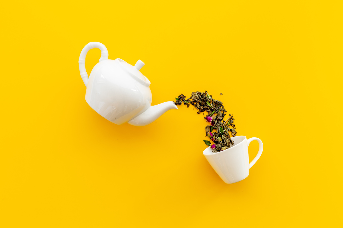Xícara e bule de chá em fundo amarelo