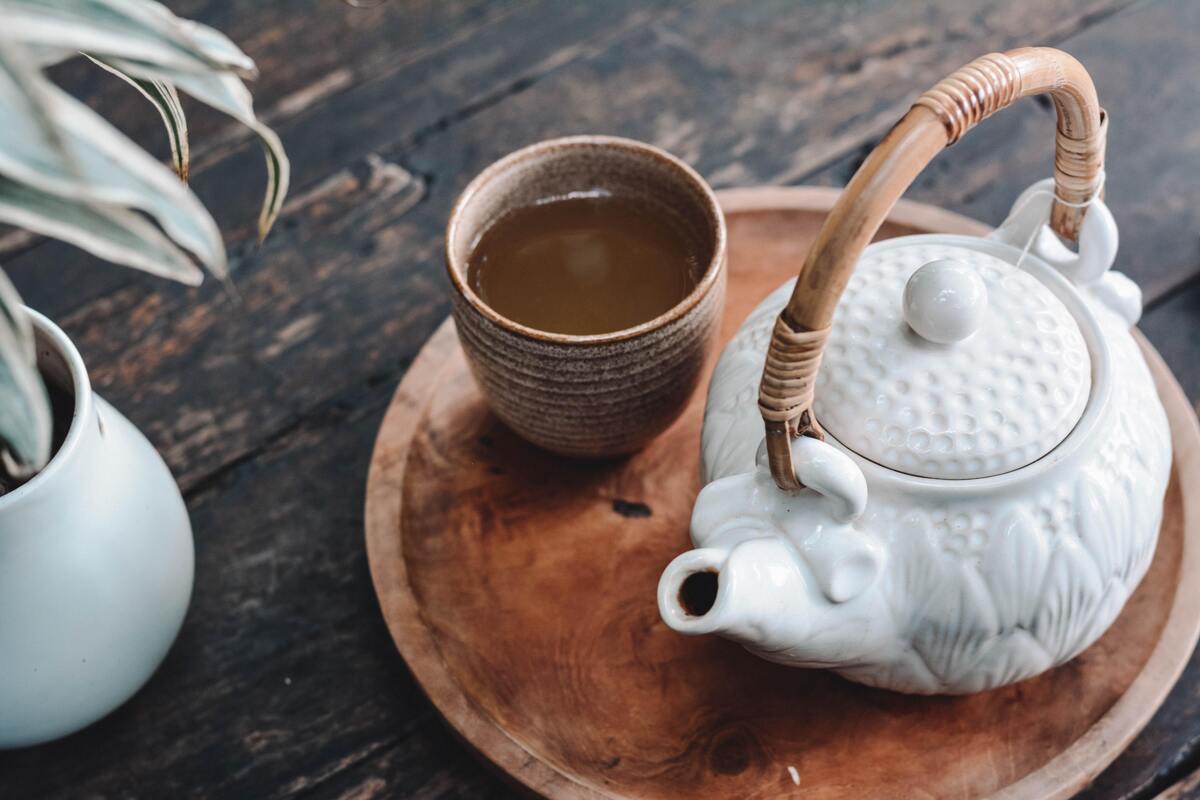 Xícara de chá e bule sobre mesa