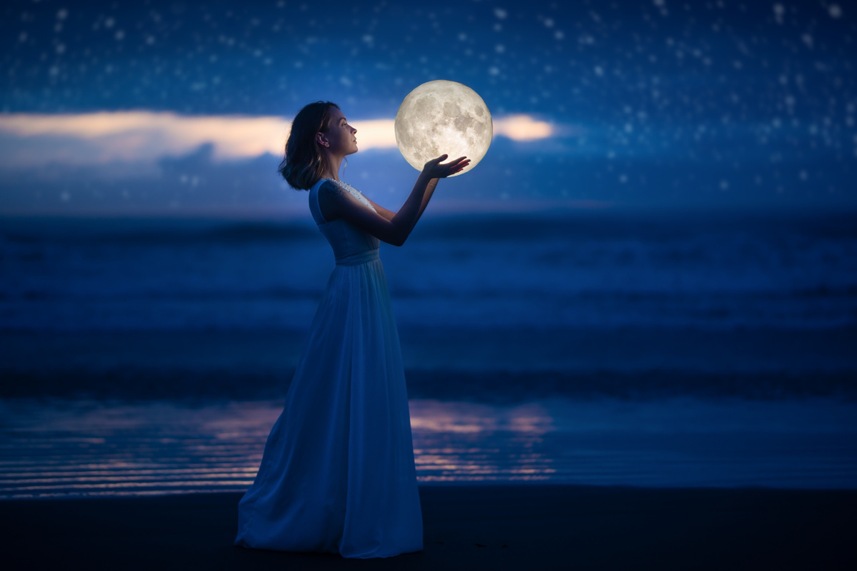 Foto com montagem de mulher segurando a lua cheia