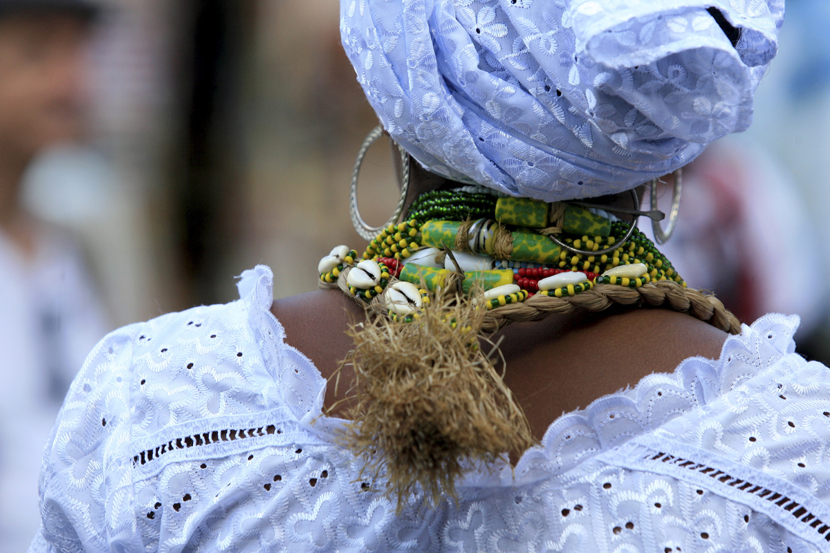 Mulher com roupas tradicionais da umbanda vista por trás