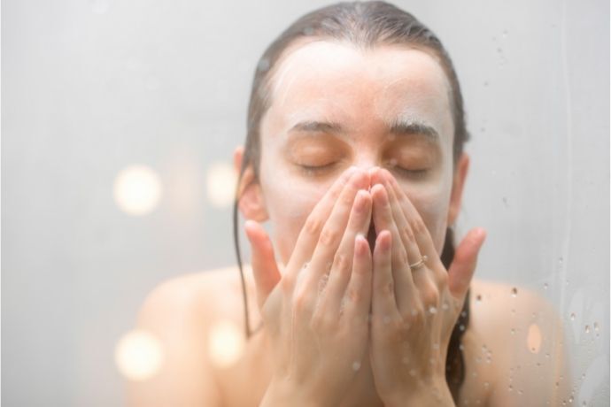 Mulher lavando o rosto com sabonete