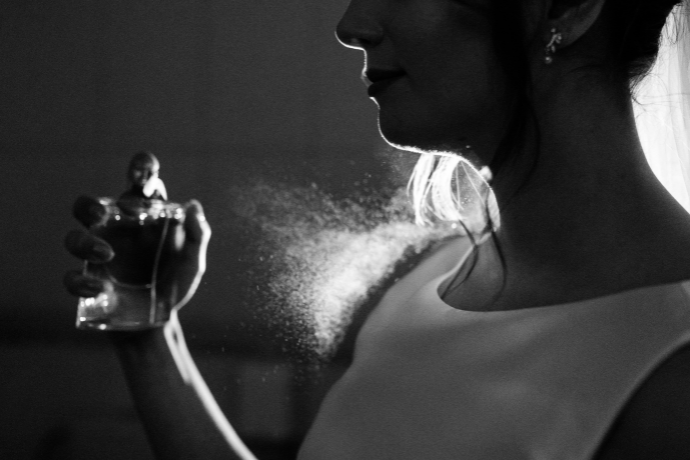 Mulher passando perfume.