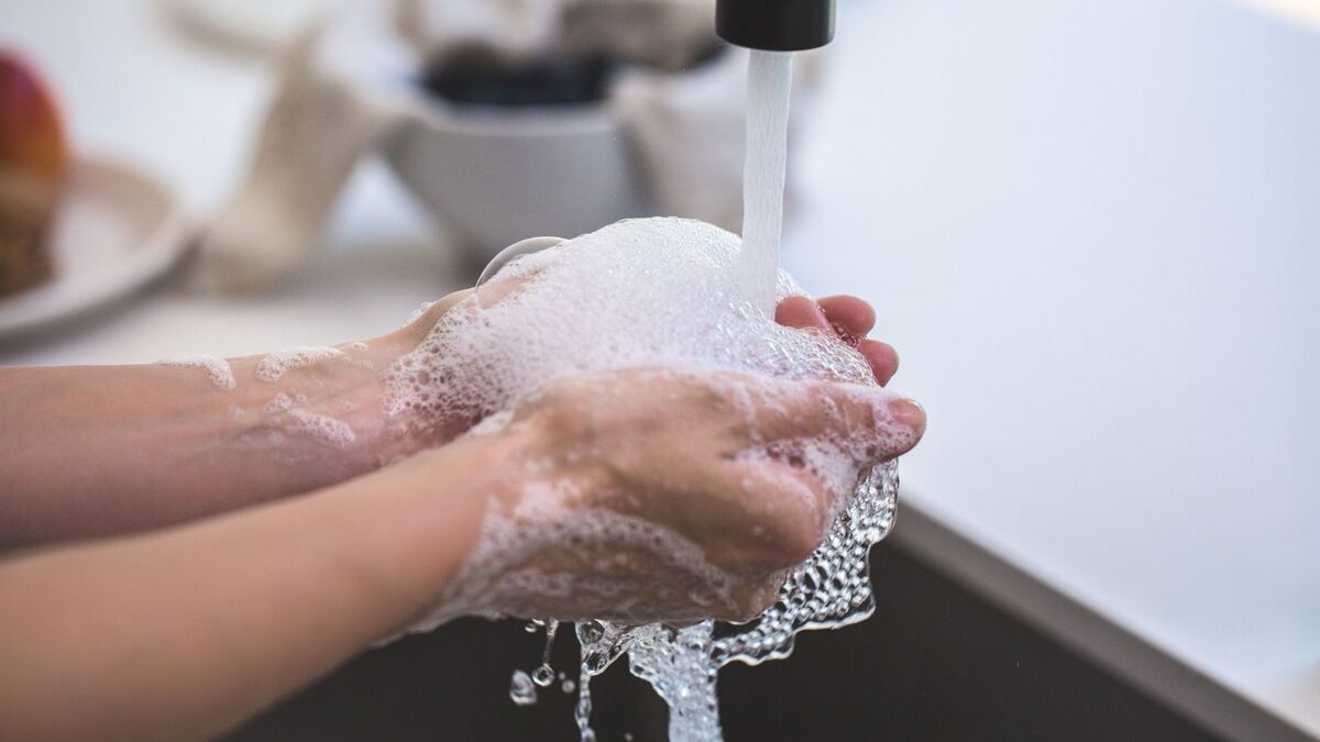 Pessoa lavando as mãos com sabonete.