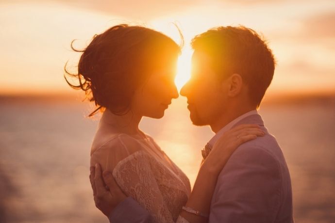 Casal se abraçando no pôr do sol