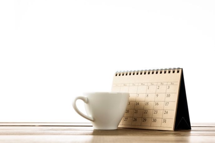 Calendário em mesa com xícara na frente