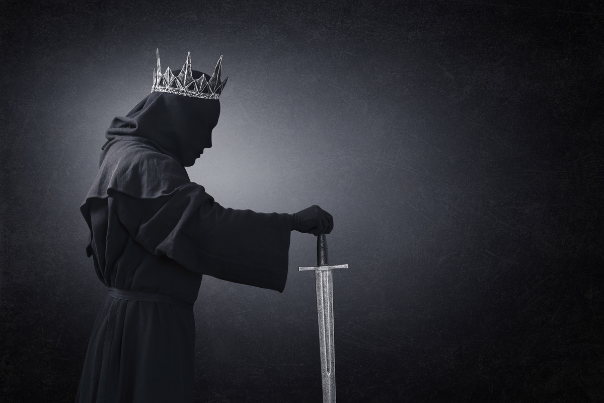 Rei com espada sozinho na escuridão
