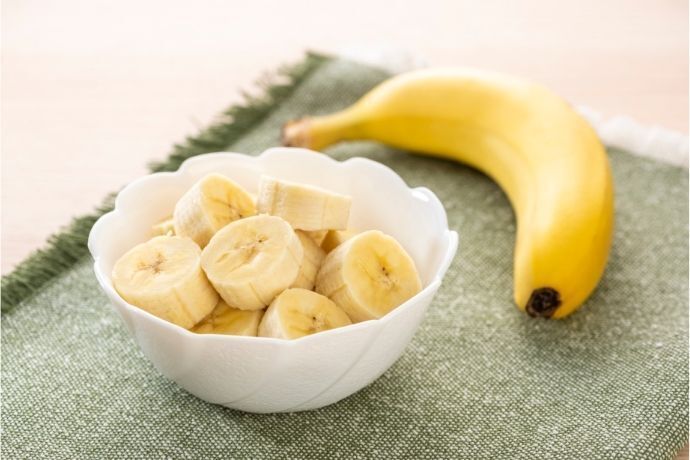 Banana inteira e pote com pedaços de banana