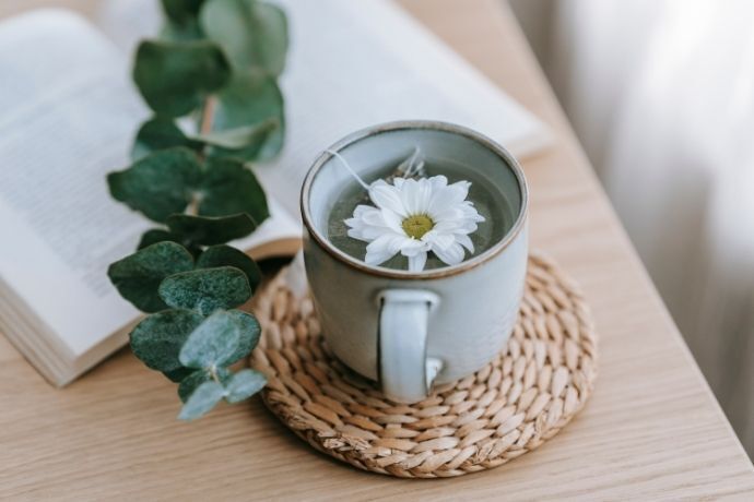 Xícara de chá de eucalipto com flor branca