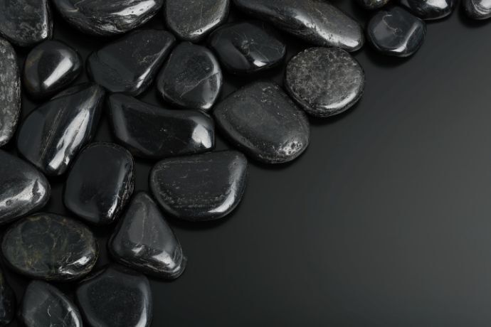 Pedras negras em superfície escura