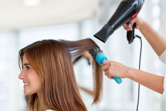Pessoa secando o cabelo de mulher com secador