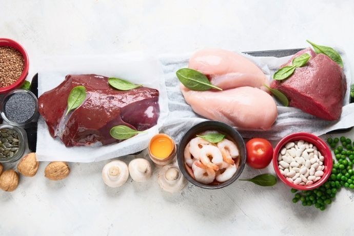 Carnes e outros alimentos ricos em ferro em mesa branca