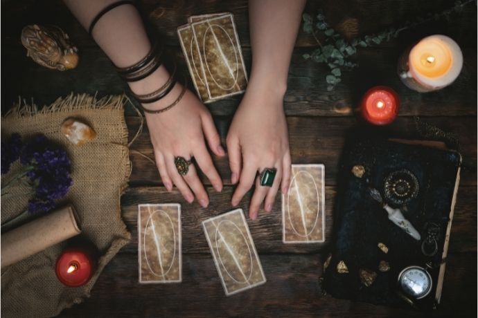 Mulher colocando cartas do baralho cigano na mesa