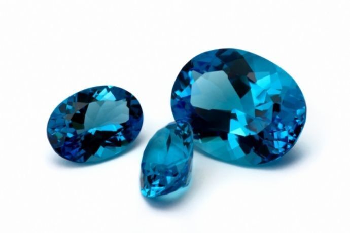 3 cristais de Topázio azul de diferentes tamanhos em fundo branco