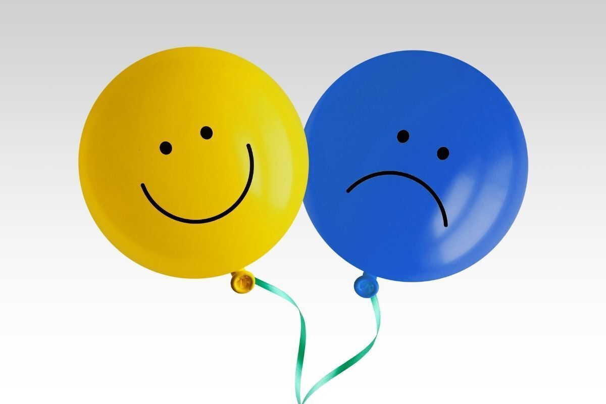 Balões feliz e triste lado a lado.