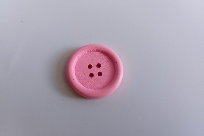 Botão rosa em superfície branca