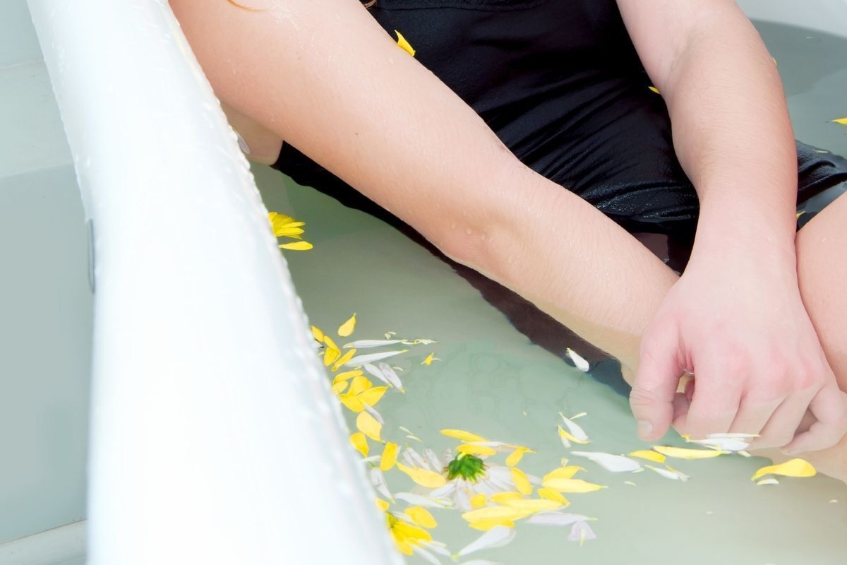 Mulher em banho de assento com flores.