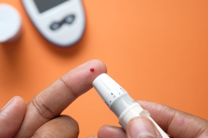 Pessoa tirando sangue para medir glicose no sangue