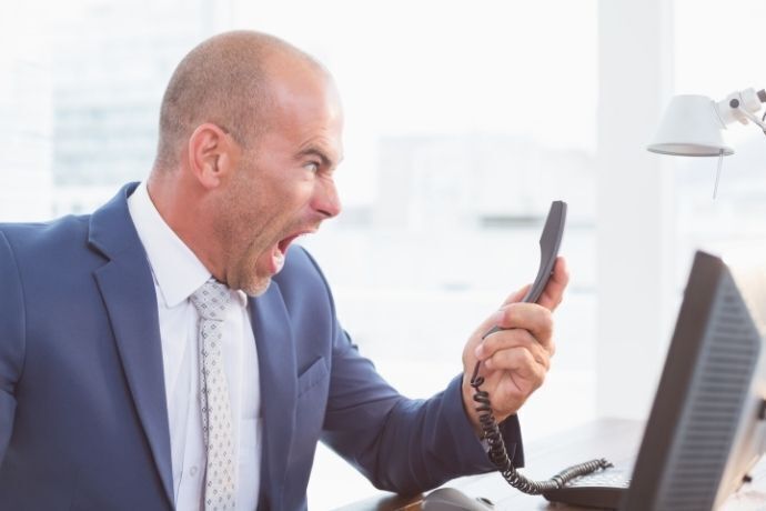 Homem de terno estressado gritando com o telefone