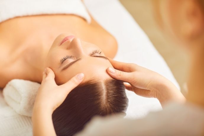 Mulher recebendo massagem na testa