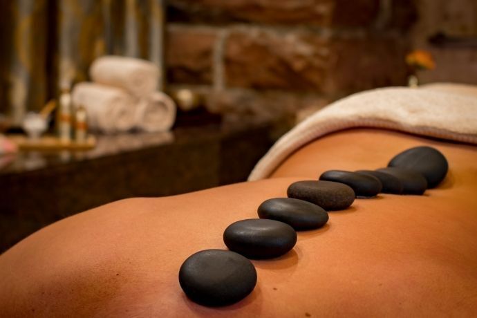 costas femininas com pedras de massagem