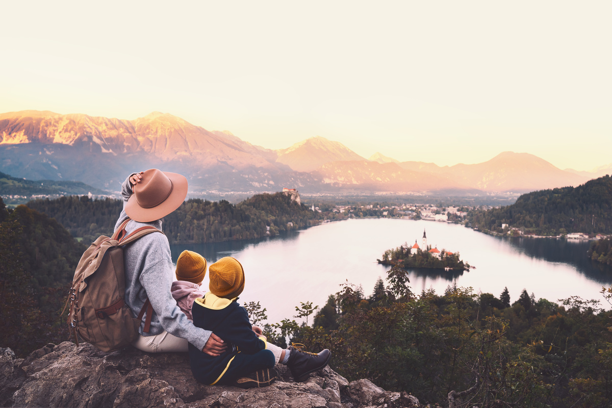 Família sentada em pedras de montanhas observando natureza de outro país.