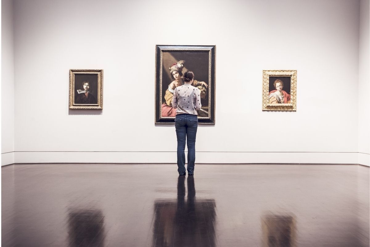 Homem observando arte em museu.