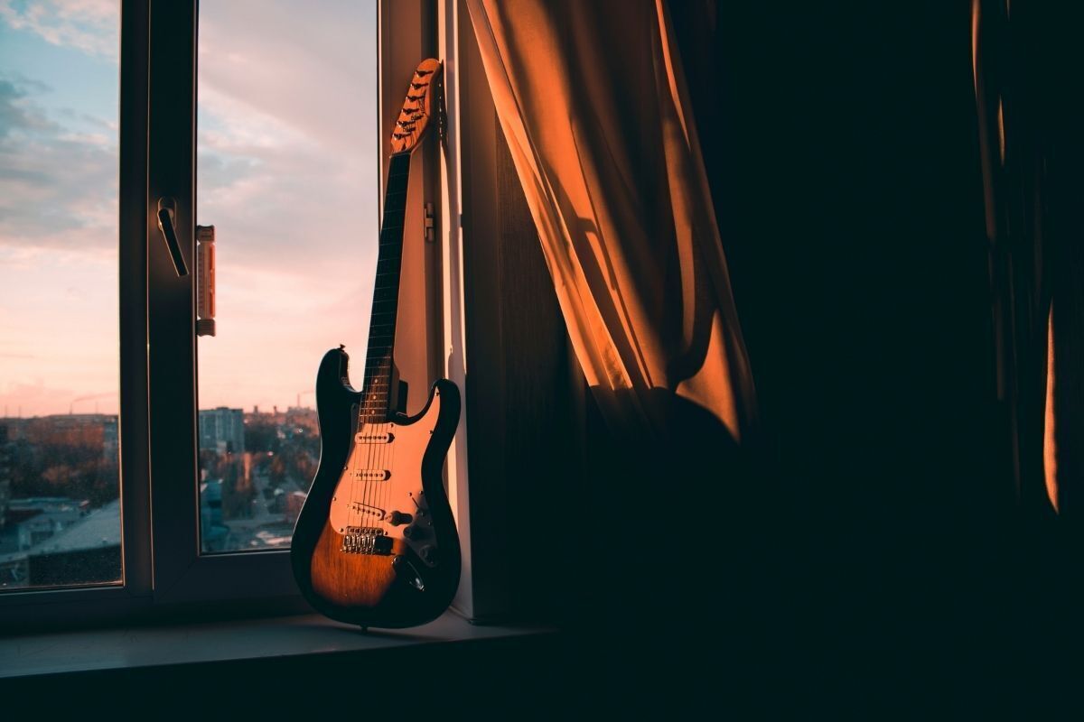 Guitarra em janela de apartamento.