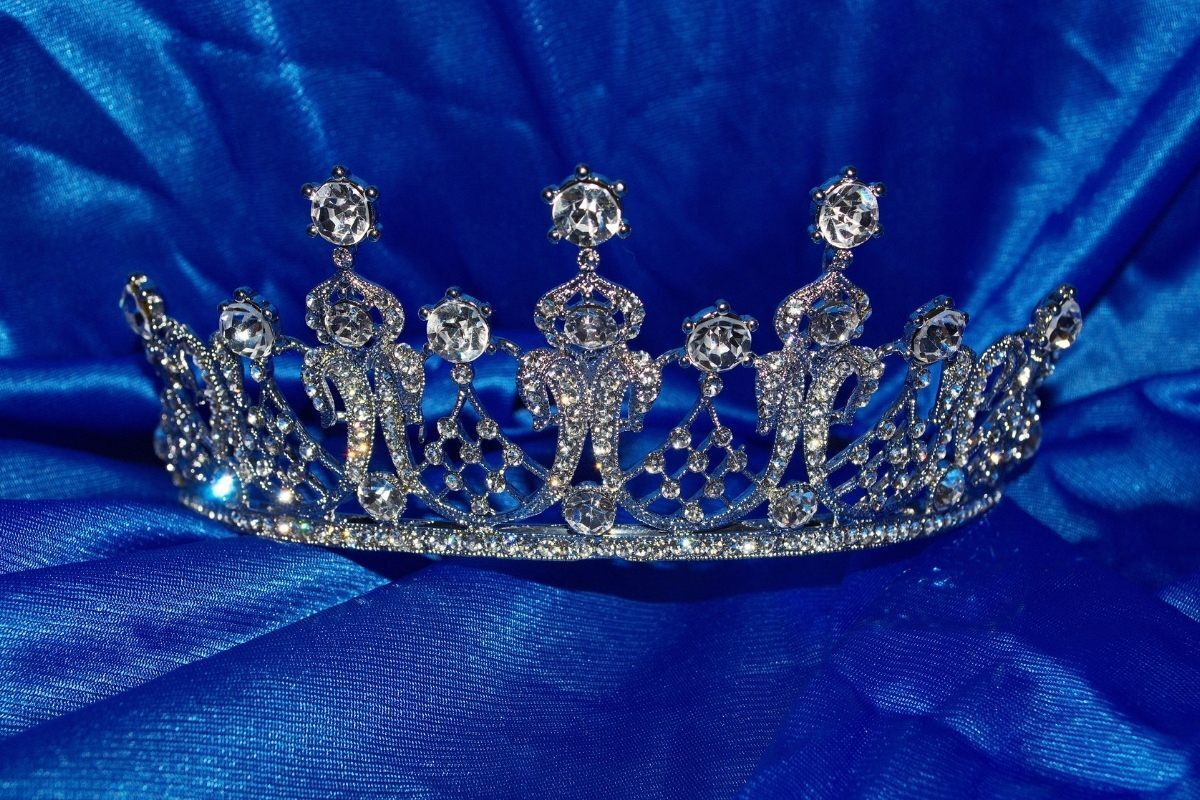 Coroa de rainha em almofada azul.