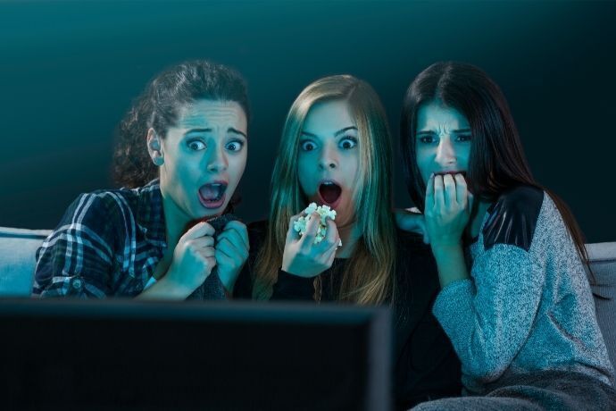 Amigas assustadas assistindo filme de terror
