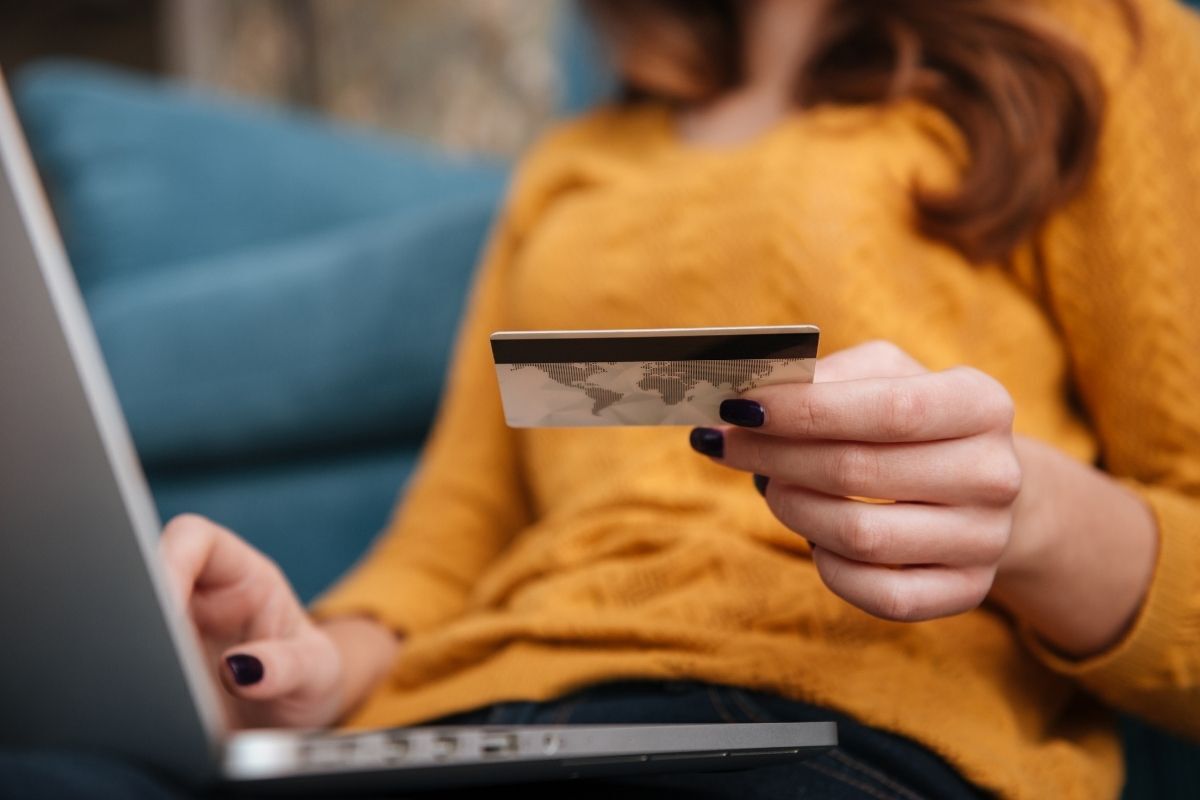 Mulher fazendo compra na internet com cartão de crédito.