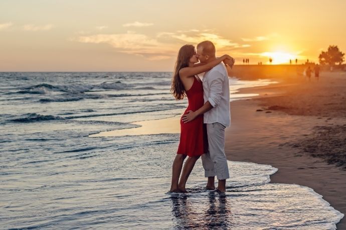 Casal se abraçando e beijando na praia 