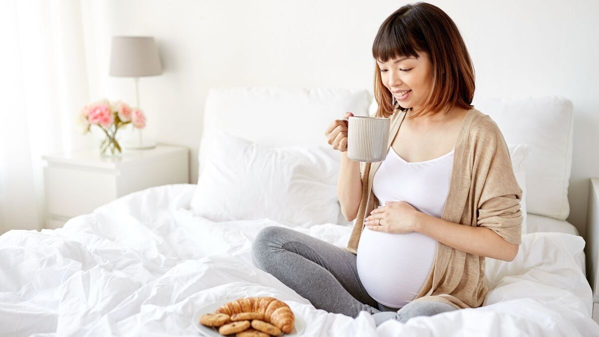 Mulher grávida tomando chá.