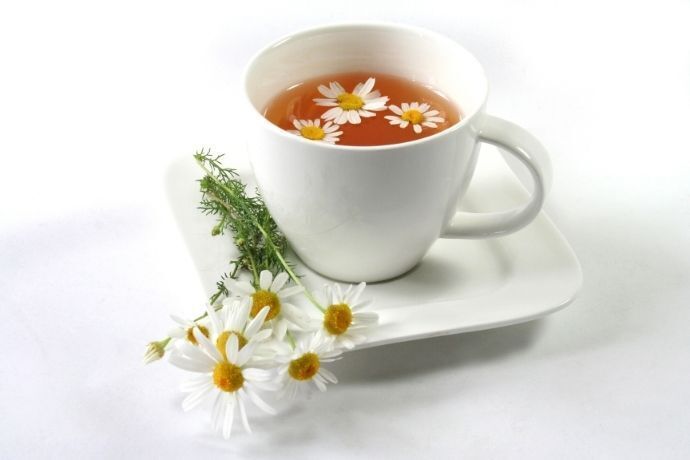 Xícara branca com chá de camomila