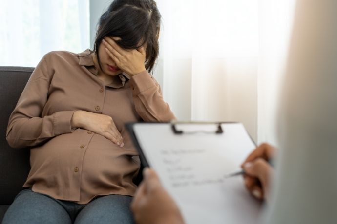 Mulher grávida na consulta com psicólogo 