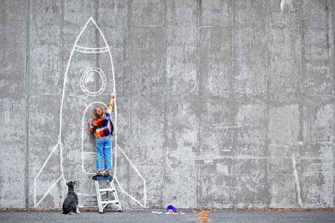 criança desenhando foguete na parede