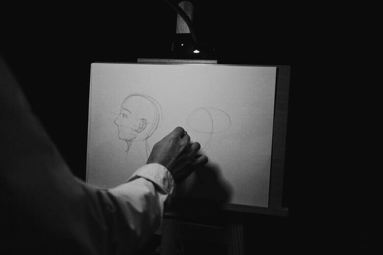 Pessoa desenhando rosto humano em papel
