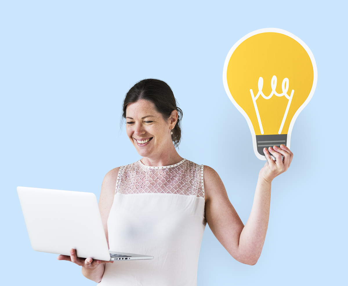 Mulher segurando notebook e uma lâmpada representando sua criatividade para o empreendedorismo