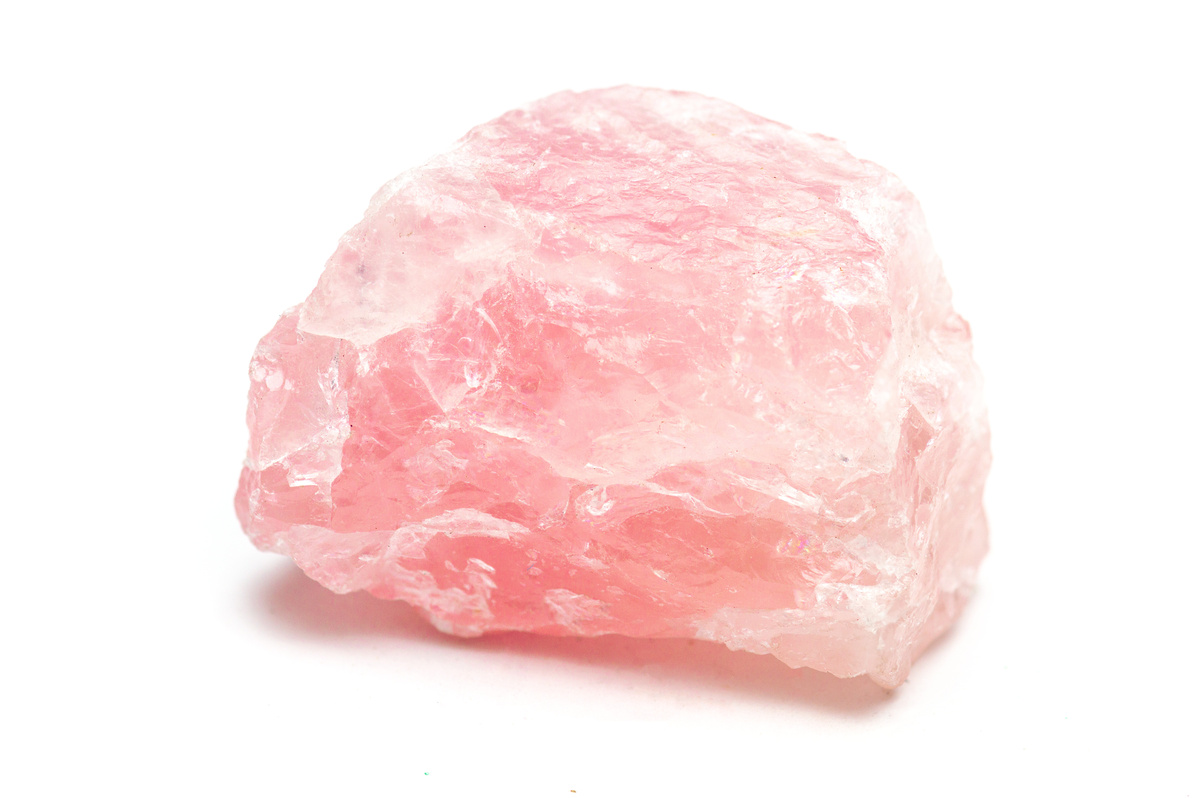 Pedra bruta de quartzo rosa em fundo branco.